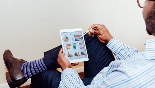 Startup business growth - tycoonstory | tycoonstory media Businessman analyzing growth charts and performance metrics on a tablet for a startup project.