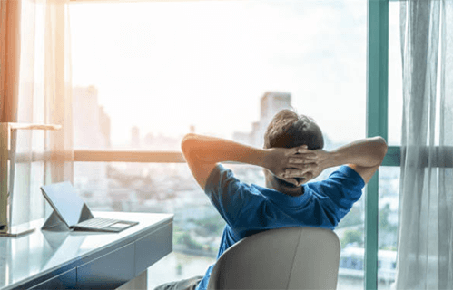 How to cope with work-related stress-tycoonstory | tycoonstory media A person relaxing and taking a moment to de-stress while looking out the window, symbolizing ways to cope with work-related stress and promote mental well-being.