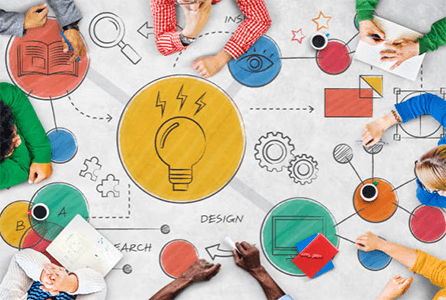 Brainstorming in a business-tyconnstory | tycoonstory media A top-down view of a brainstorming session, showing colorful mind maps and designs, as participants share ideas and work on solutions.