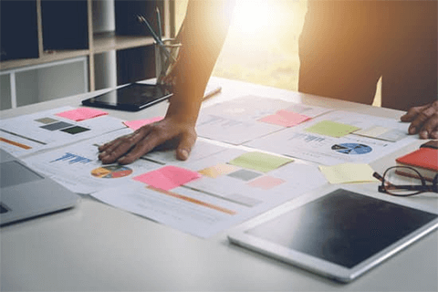 Create a strategy a business strategy-tycoonstory | tycoonstory media Business strategy meeting with documents and charts on a table, showcasing the planning process for companies aiming to expand globally.