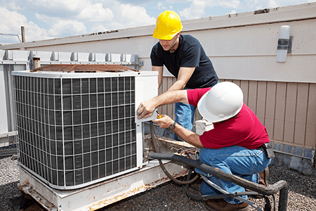 Tips for commercial hvac maintenance-tycoonstory | tycoonstory media Two professionals working on an hvac system, repairing and maintaining rooftop air conditioning units to ensure optimal performance.