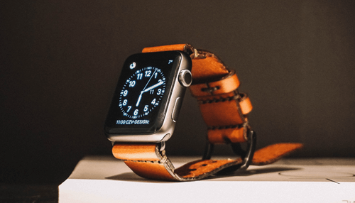 Apple watch An elegant apple watch with a leather strap, displaying the time on a sleek black screen, emphasizing its stylish design.