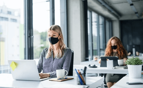 Offices after the pandemic-tycoonstory | tycoonstory media Women working on laptops in a bright, socially distanced office environment, showing how the coronavirus pandemic has changed daily work routines.