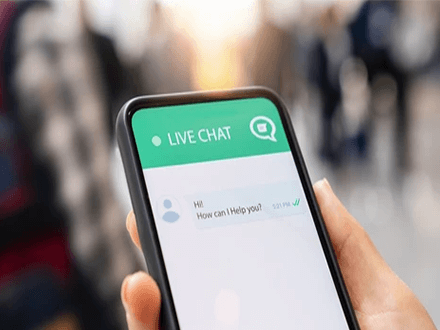 Live chat A close-up of a phone screen with a live chat window open, showing the greeting'Hi! How can I help you?' as part of a customer feedback process.