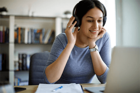Stay connected while working from home-tycoonstory | tycoonstory media Woman wearing headphones and smiling during an online call, showcasing comfort and efficiency of working from home.