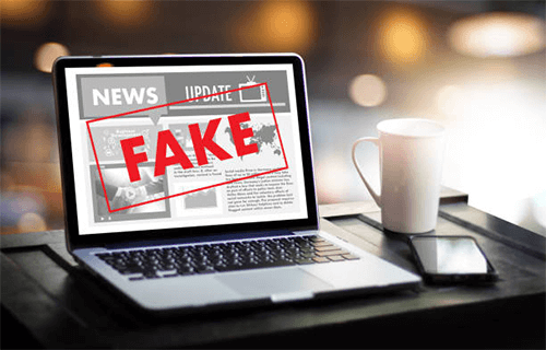 Fake news A laptop displaying a news article with a large fake news stamp over it, representing the spread of fake news in the digital age.