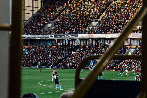 Owning a championship club-tycoonstory | tycoonstory media View of a crowded football stadium during a match, reflecting the experience of owning a championship club.