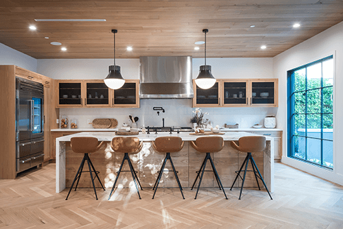Kitchen island pendant Contemporary kitchen design featuring wooden accents, bar stools, and stylish kitchen island pendant lighting above the countertop.