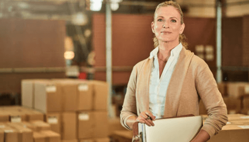 Laboratory equipment’s Warehouse manager inspecting inventory with clipboard near packaged goods related to laboratory equipment’s