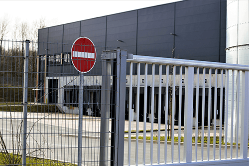 Install security fencing to protect your business property-tycoonstory | tycoonstory media Security fence surrounding a business property with a no-entry sign to deter unauthorized access and protect the premises.