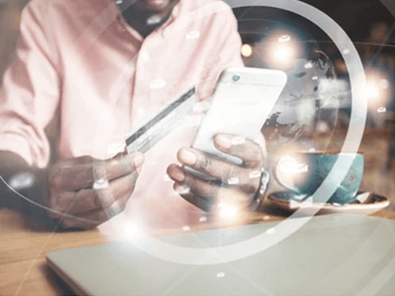 International payments A person making a payment using a smartphone and a credit card, symbolizing the use of payment gateway for online transactions.