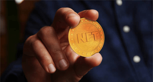 Nfts-tycoonstory | tycoonstory media Close-up of a person holding a golden nft coin, symbolizing ownership and investment in non-fungible tokens.