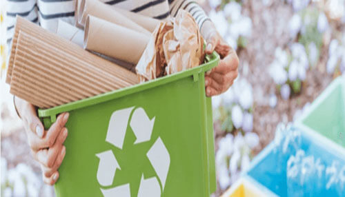 Ecological-friendly Person holding a recycling bin filled with paper waste, symbolizing the eco-friendly aspect of document scanning and reducing paper usage.
