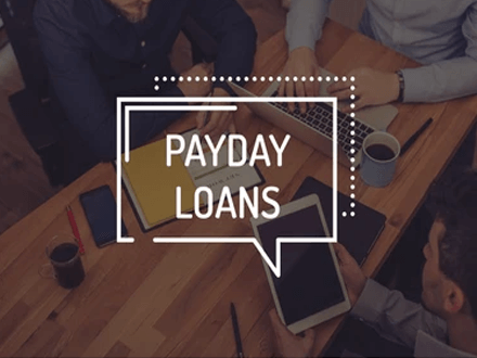 Payday loans - tycoonstory | tycoonstory media Group of people discussing payday loans with tablets and documents on a wooden table, illustrating short-term lending.