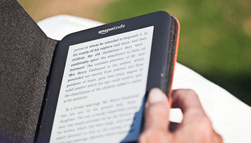 Amazon kindle - tycoonstory | tycoonstory media An amazon kindle being used outdoors, showcasing a smart reading device often chosen as practical gifts for entrepreneurs.