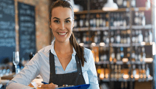 Selling your small business Selling your small business owner confidently managing daily operations inside a retail or hospitality setting, representing overconfidence during the business sale process.