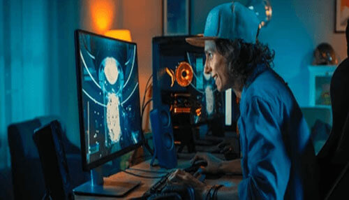Dedicate time to playing your games A gamer focused on playing at a computer desk, showcasing an intense video gaming setup with high-tech equipment and an illuminated gaming environment.
