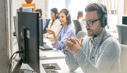 Listen to the needs and pains of your client Sales agent wearing a headset communicating with clients in an office environment, providing customer support and assistance.