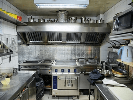 Ventilation Well-equipped restaurant kitchen showing commercial appliances, including stove, oven, and ventilation system, illustrating a professional cooking environment.
