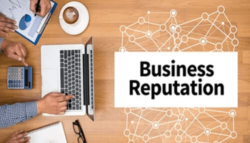 Business reputation Business professionals analyzing data on a laptop, emphasizing the importance of business reputation in preventing annual fraud.