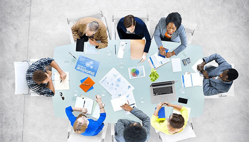 What type of consultant firm to choose Consulting business team collaboration shown through a diverse group reviewing plans, reports, and data during a business meeting