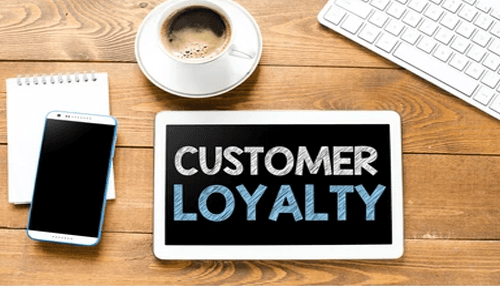 Building customer loyalty Tablet displaying customer loyalty concepts on a work desk, representing customer success strategies focused on retention, engagement, and long-term business growth.