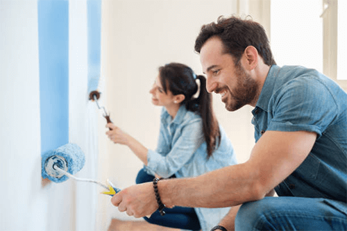 Paint wall mural Couple painting an interior wall at home as a simple diy way to decorate your large blank wall.