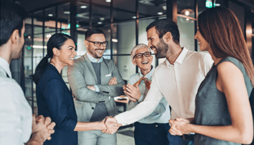 Startup advisor Business woman and man shaking hands in an office, surrounded by colleagues, welcoming a new startup advisor.