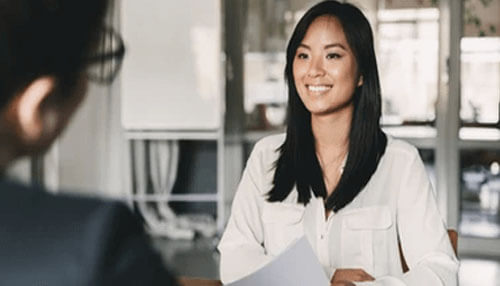 People you hire are important A young woman smiling during an interview, representing the importance of hiring the right people for growing a small business