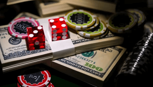 Casino deposits A stack of one-hundred-dollar bills topped with red glass dice and professional poker chips, symbolizing luxury gaming and betting.
