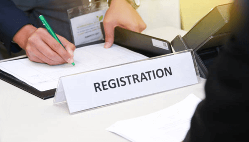 Register your business Person filling out a form at a registration desk for registering a business in singapore.