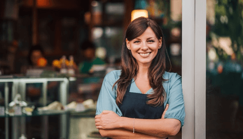 Launching A Startup Smiling woman entrepreneur standing confidently outside her cafe, ready to embrace the challenges of launching a startup.