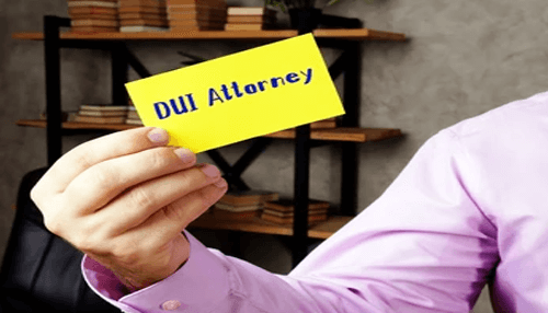 Duties of an oui/ dui attorney Person holding a yellow card that reads “dui attorney,” representing legal help for dui cases.
