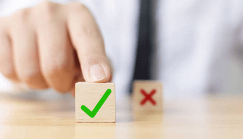 Have-the-right-equipment-tycoonstory-1 | tycoonstory media Hand pointing to a wooden block with a green checkmark, symbolizing choices to keep a small business afloat, with a red x nearby.