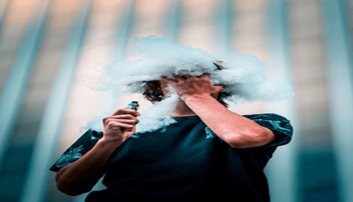 Difference between smoking and vaping Individual vaping, surrounded by a large cloud of vapor, showcasing the role of e-juices in producing smoke effects.