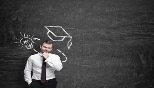 Stringent qualifications Entrepreneur standing thoughtfully in front of a chalkboard with idea sketches, symbolizing planning and strategy for launching your startup.