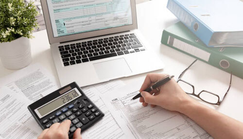 Accounting isn't boring - tycoonstory | tycoonstory media Small business accounting process showing tax documents, calculator, laptop, and financial paperwork for accurate bookkeeping.