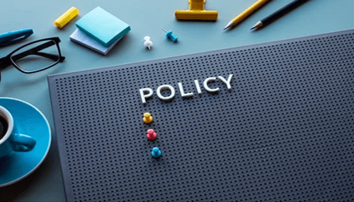 Assessing the policy Office desk with a board displaying the word “policy,” symbolizing workplace guidelines and the importance of an ohs policy.