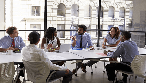 Face-to-face meeting - tycoonstory | tycoonstory media A team of professionals collaborating in a meeting, representing teamwork and strategy in a small business environment.