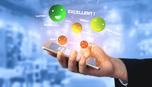 Feedback management Hand holding a phone with digital feedback icons, showing review features in a property management app.