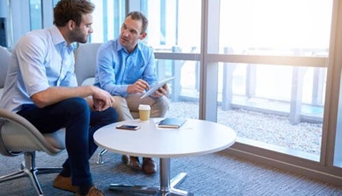 Practice assertive conversation Khattab engaged in a professional business discussion, collaborating with a colleague to share insights, ideas, and strategic decision-making.