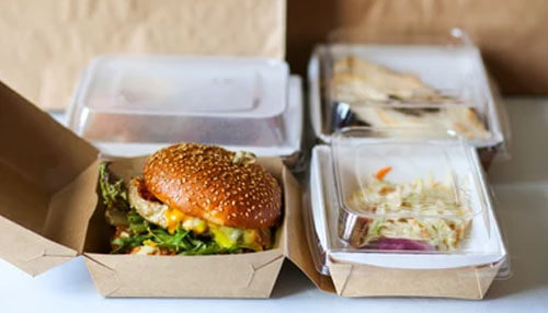 Sandwich and Salad Delivery Packed burger and meal in takeaway boxes, highlighting eco-friendly food delivery packaging solutions.