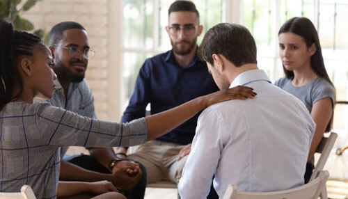 Show compassion A supportive group collaborating in a counseling or team-building session, offering comfort and guidance, showcasing the power of collaboration in personal growth