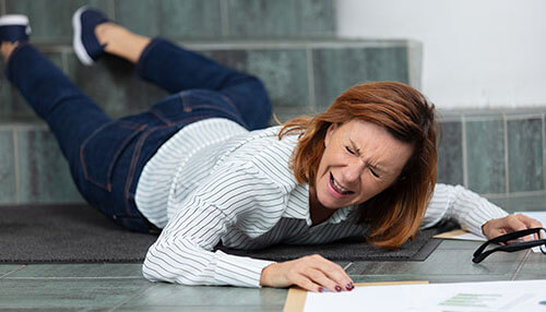 Slip and fall accidents Woman slipping and falling on stairs while holding documents and glasses