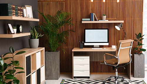 Welcome the greens Modern and stylish office space with a computer desk, chair, plants, and wooden wall décor.