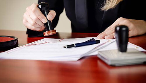 Procedure for extension of validity of registration certificate Professional stamping official documents on a desk, illustrating verification and paperwork for gst registration.