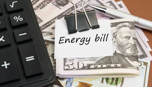 Reduced energy bills Energy bill with calculator, pen, and cash, representing the cost of electricity and household expenses.