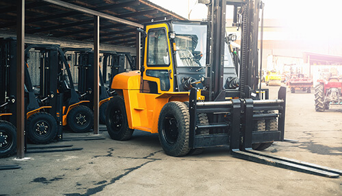 Renting a forklift A forklift parked in a storage area, demonstrating the versatility and efficiency of forklifts for handling heavy materials.