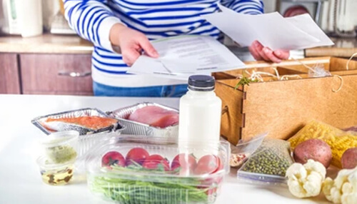 Restaurant meal kits Meal kits dublin packaging with vegetables, salmon, and instructions on a kitchen counter.