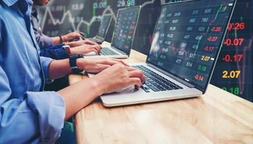 Bitcoin exchange platforms Traders analyzing cryptocurrency price charts on laptops, representing bitcoin exchange platforms used for trading digital currencies.